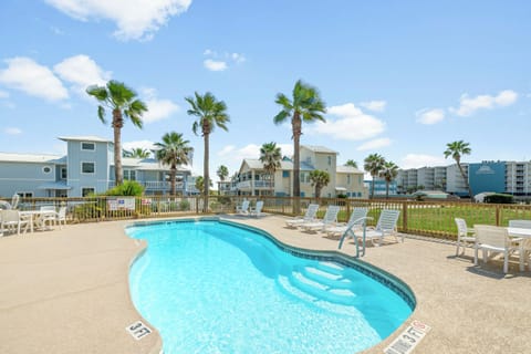 Sparkling pool surrounded by palm trees and lounge chairs creates your perfect coastal escape.