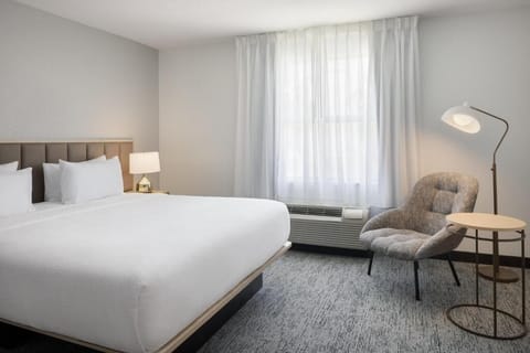 Unwind in crisp linens beside soft light and calm tones.