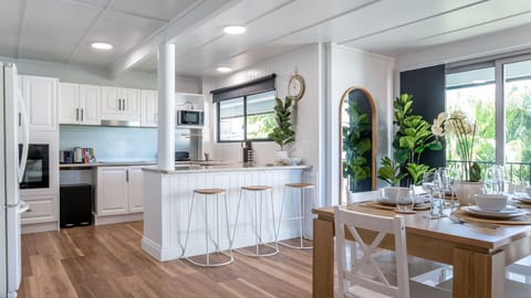 Open-plan kitchen and dining area with breakfast bar, modern appliances, and stylish decor