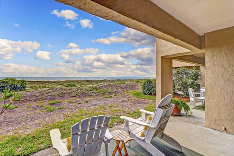 Private oceanfront patio with Adirondack chairs and dune views, just steps to the beach—perfect for relaxing with coastal breezes and sunset skies.