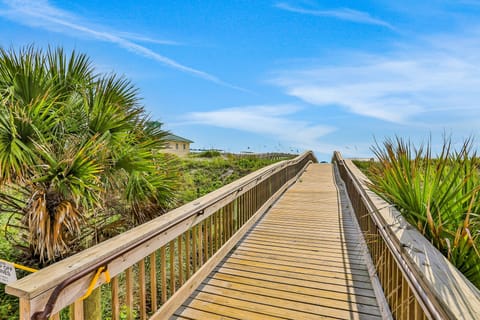 Soft sandy shores stretch along the coastline as gentle waves roll in, with sea breeze in the air—perfect for relaxing, strolling, and soaking up the sun.