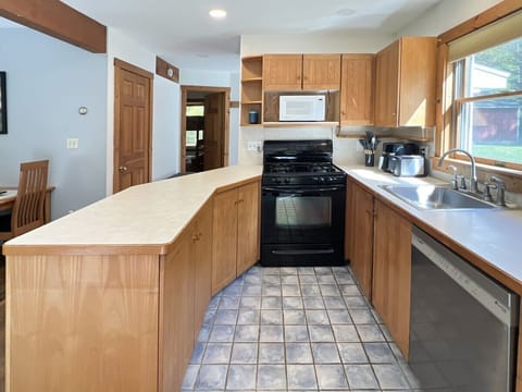 Fully equipped kitchen with range, ample cabinet storage, and plenty of prep space.
