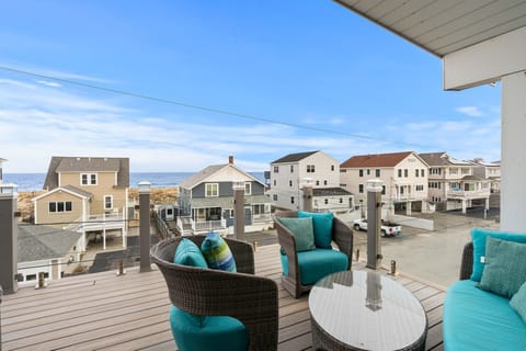 Rooftop deck with ocean views, outdoor furniture, and access to the living room and primary bedroom. 