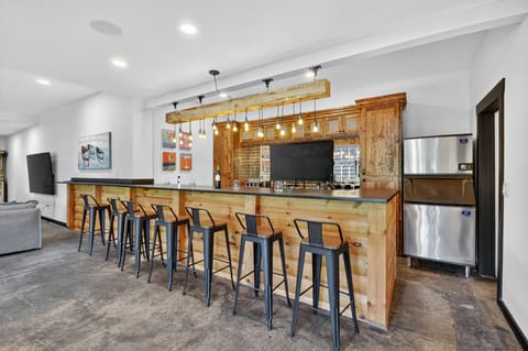 This luxury Ellijay cabin rental features a full bar area with seating, industrial ice machine, and the feel of a private pub