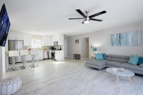 Open-concept living room with a cozy sectional, Smart TV, and sliding glass doors filling the space with natural light.