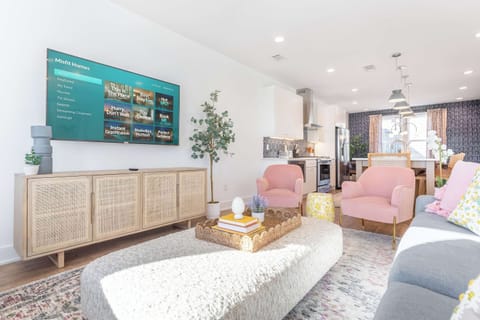 A living room built for the whole crew: plenty of seating, a full entertainment setup, and sightlines to the kitchen so nobody misses out on the action