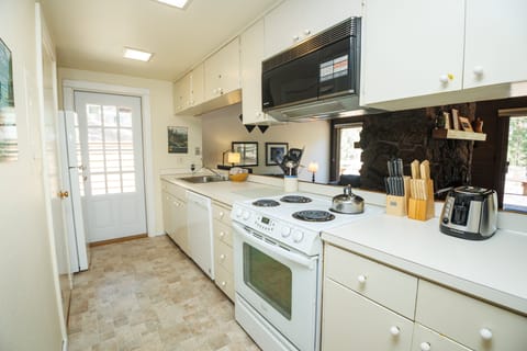 The Kitchen is just down the hall from the Entry and has a door out to the deck area