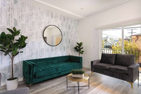 Bright living room with modern decor and cozy green velvet sofa