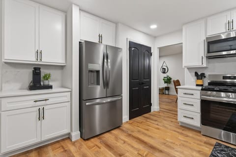 Discover a beautifully remodeled open-concept kitchen with a coffee bar, new appliances, quartz countertops, and backsplash. Perfect for cooking, entertaining, and relaxing, it combines modern style and seamless functionality for ultimate comfort.