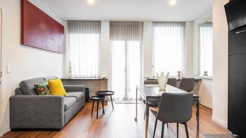 Bright living room with sofa, dining table, and large windows