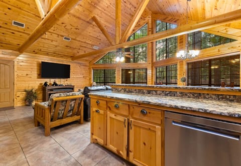 Open kitchen flows into living area with forest views all around