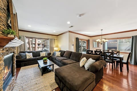 Sink into this plush sectional by the crackling fireplace, where rich hardwood floors and mountain views create your perfect retreat.