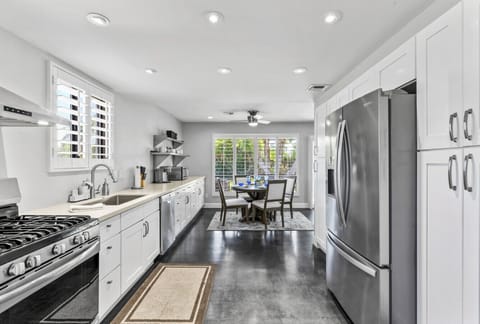 Spacious, modern kitchen with stainless steel appliances, granite countertops, and dining for six.