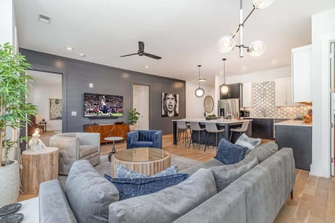 Bright open floor living space featuring designer furnishings and a smart flat-screen TV, and access to a private balcony.