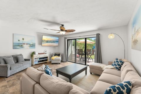 Spacious living room with sliding glass doors opening to a patio with outdoor seating.