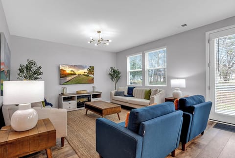 Cozy modern living room with natural light, comfy seating, and a smart TV