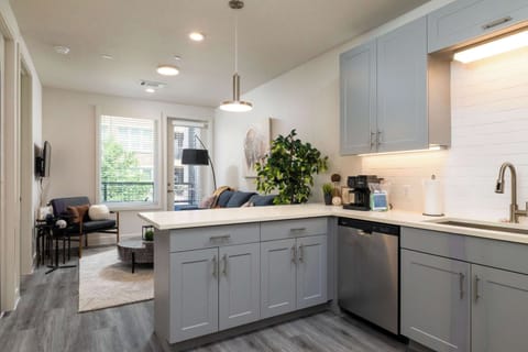 Compact kitchen fully stocked with all essentials and sleek stainless steel appliances—everything you need in a cozy space.