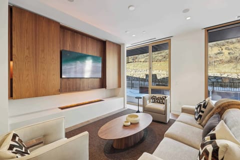 Unwind in your modern living space with plush seating, stunning mountain views, and cozy fireplace ambiance.