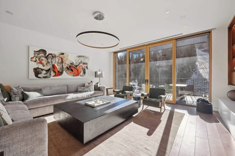 Unwind in your stylish living room where contemporary art meets mountain views through floor-to-ceiling windows.