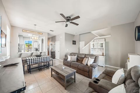 A bright living room with a large sectional sofa and natural light pouring through the patio doors.