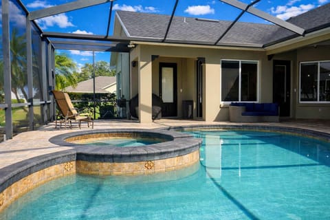 Private screened pool area with attached spa and outdoor seating for relaxation.