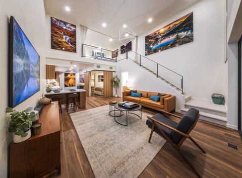 Stunning living room with 25-ft ceilings, fine art, Large Smart TV,Designer furn