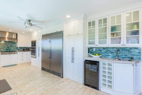 With coastal hues and premium finishes, this open-concept kitchen is as beautiful as it is functional—an entertainer’s dream with ocean vibes throughout