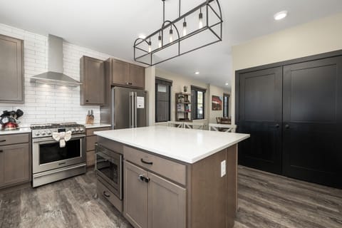 Your fully equipped kitchen features sleek appliances, spacious island, and modern lighting perfect for preparing memorable meals.