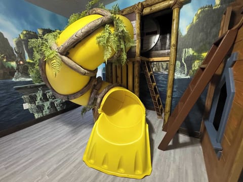 Kids will love this unique bunk room featuring an exciting slide, making bedtime an adventure every night