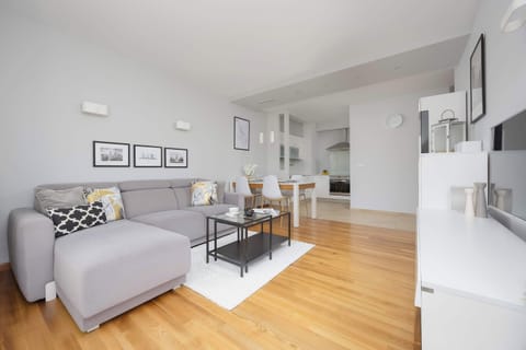 A bright living room with a large window and a comfortable sofa invites relaxation, creating a space perfect for spending time together.