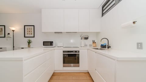 Kitchen with sleek white cabinetry and appliances.