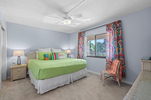 Enjoy a restful beach stay in this cheerful bedroom featuring tropical décor, vibrant colors, and a plush king bed—perfect for unwinding after a day by the ocean.