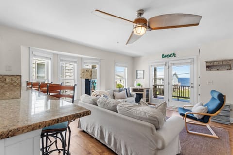 Spacious, comfortable living room with beautiful ocean views. Multiple windows fill the space with natural light.