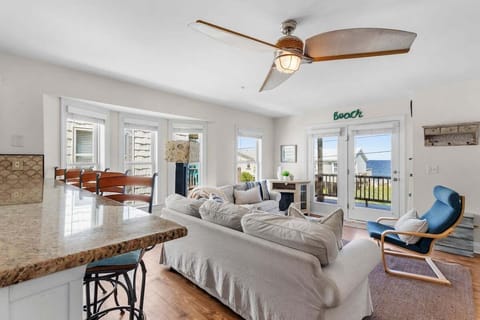 Spacious, comfortable living room with beautiful ocean views. Multiple windows fill the space with natural light.