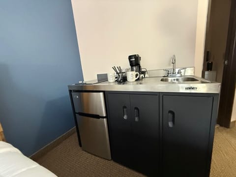 Functional kitchenette area offering a mini-fridge and prep sink.