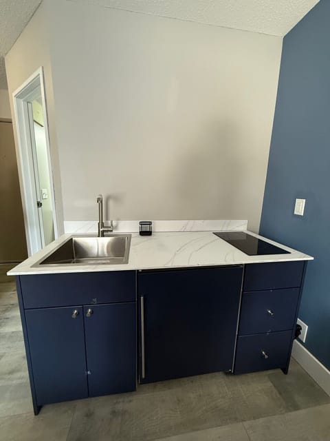 Updated kitchenette offering marble-style counters and a sleek stovetop.
