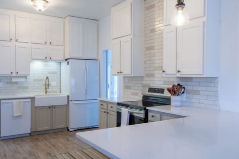 Kitchen with oven, stove, dishwasher and full-size refrigerator, coffee station.