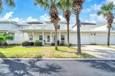 Welcome to Take It Breezy, a charming coastal home featuring tropical landscaping with mature palm trees and a welcoming front porch in a peaceful residential neighborhood.