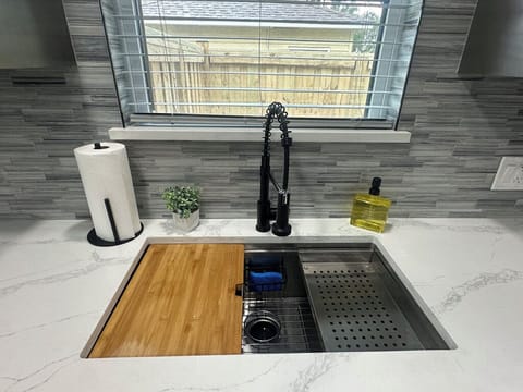 Large sink with removable cutting board and strainer.