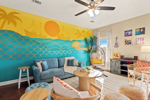 Kick back in this vibrant coastal lounge where sunny murals, retro tunes, and chill vibes set the scene for carefree beach days and late-night laughs.
