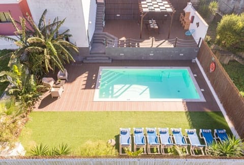 Piscina privada com espreguiçadeiras, deck ceramico e zona de lazer exterior.