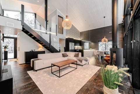 The open-plan living area is the heart of the home. It includes a modern lounge with large sofas, a flat-screen TV, and beautiful views of the surrounding nature. The stylish Nordic interior blends wood, light, and space to create a calming atmosphere – p