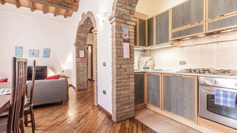 Zona living dotata di tavolo da pranzo, divano, tv e angolo cottura dotato di forno e fornelli 