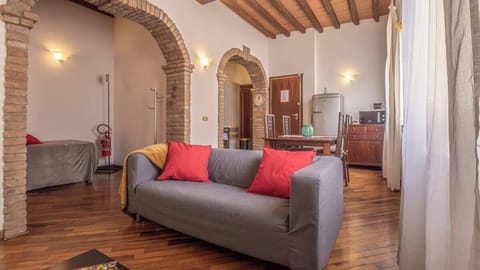 Zona living con tavolo da pranzo, divano, angolo cottura e frigorifero