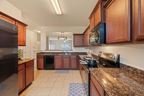 Fully equipped kitchen with air fryer, stove, fridge, and dishwasher