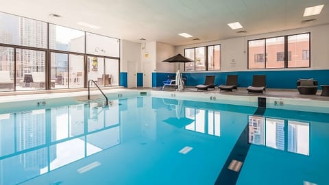 Dive into a sparkling indoor pool with city reflections.