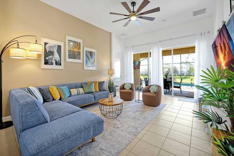 Spacious living room with a large sectional sofa and sliding doors opening to a poolside patio.