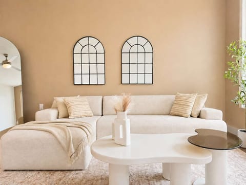 Spacious living room featuring a cozy L-shaped sofa, a full-size air mattress, and a 65" Smart TV with preloaded access to Netflix, Hulu, and Disney+, all set up for your enjoyment.