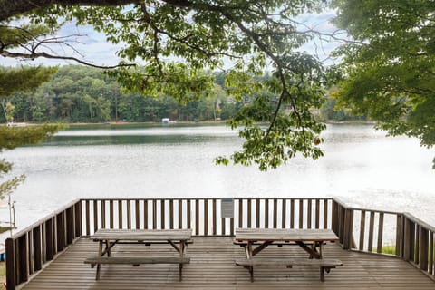 Spacious lakeside deck w/ railing seating, perfect for morning coffee under the trees