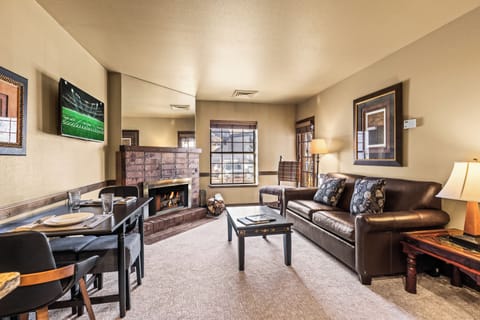 A cozy living room with one sofa, TV, gas burning fireplace, and dining table for two guests.